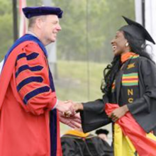 President Schmidt shakes hands with a graduate at Commencement